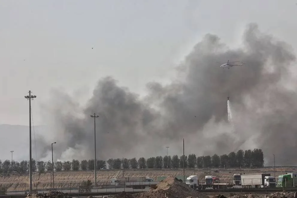 Un helicóptero arroja agua sobre el incendio en el puerto Shahid Rajaei, en Bandar Abbas (EP)
